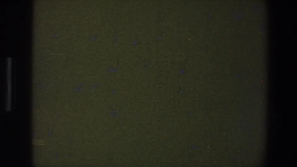 1973 Saint Paul 8mm frame showing a mostly blank dark field with gate shadows, grain, and small dust marks.