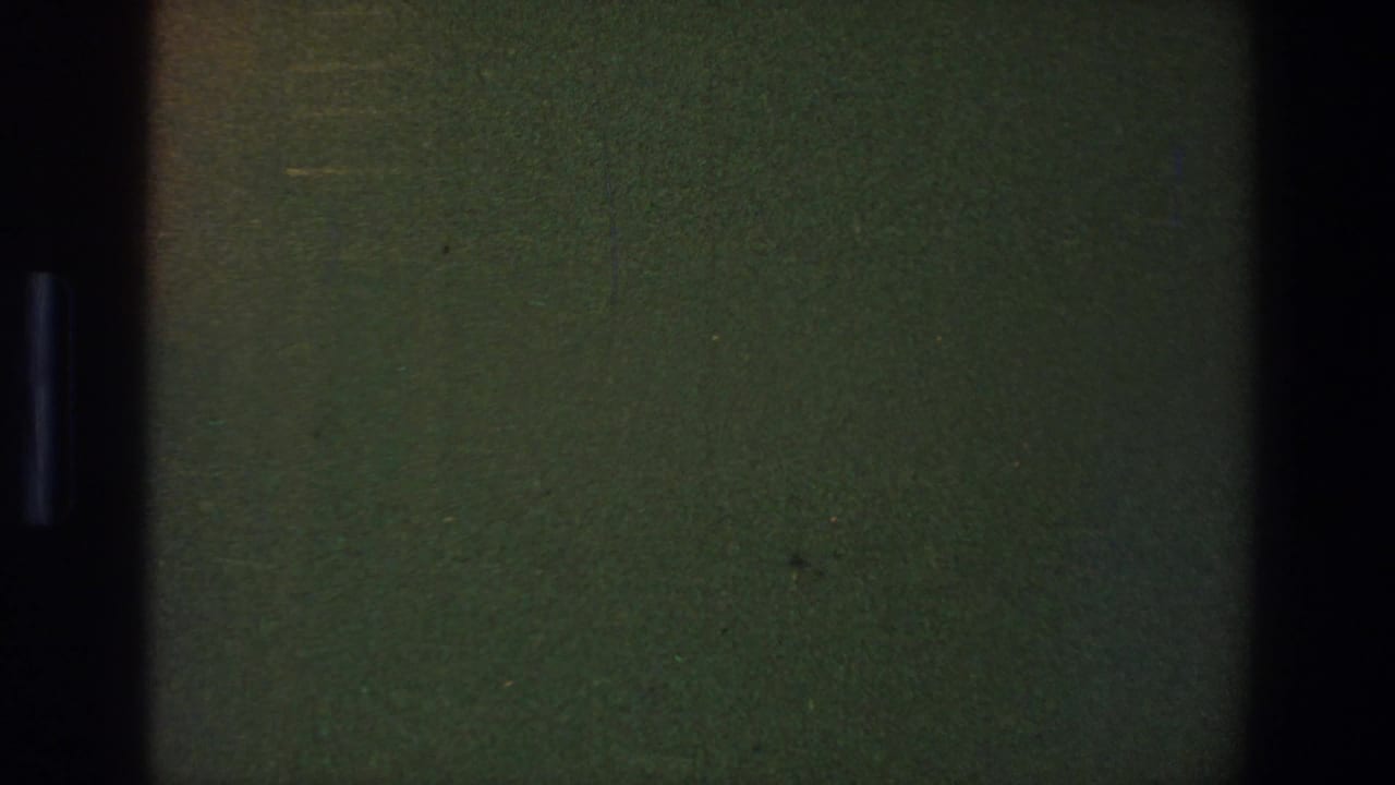 1973 Saint Paul 8mm reel frame showing a dark green blank film area with black gate edges, grain, and faint speckling.