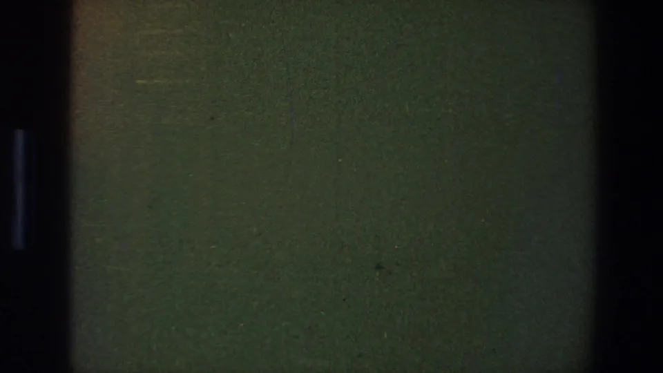 1973 Saint Paul 8mm reel frame showing a dark green blank film area with black gate edges, grain, and faint speckling.