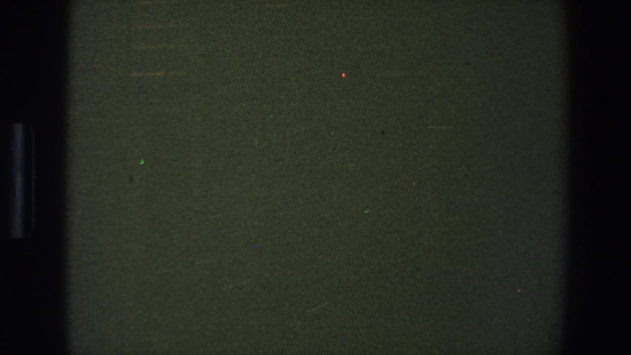 Dark green blank film frame with a central black vertical strip and small specks.
