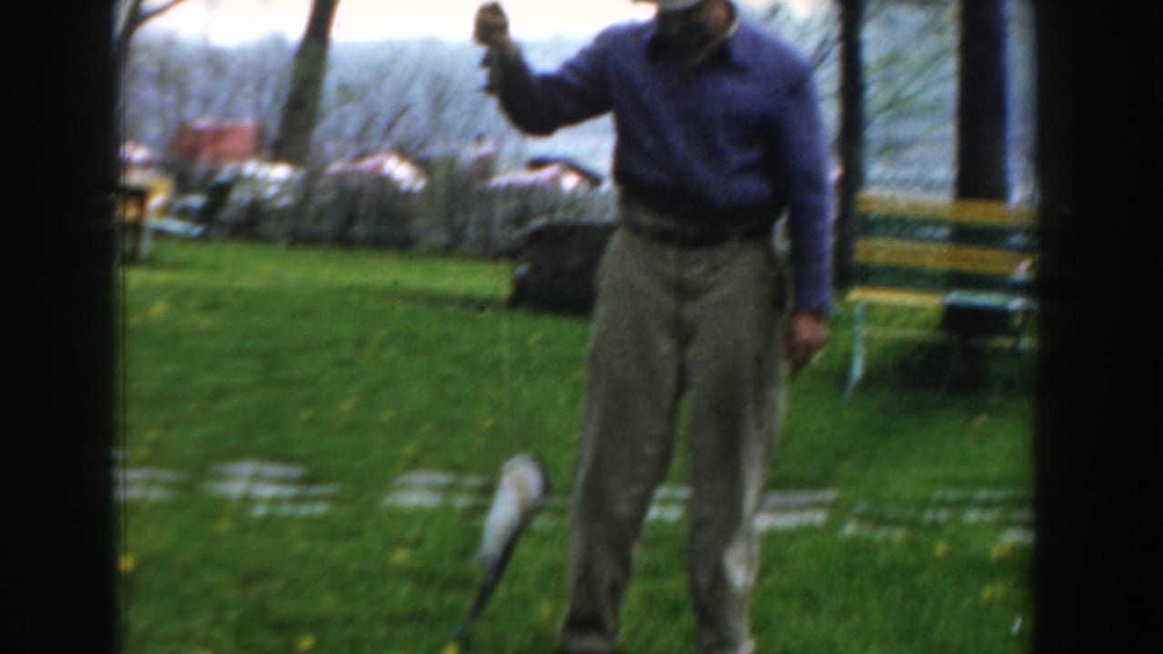 In 1961 Novi, Michigan home-movie footage, a man stands in a grassy park holding a small shark or fish on a pole.