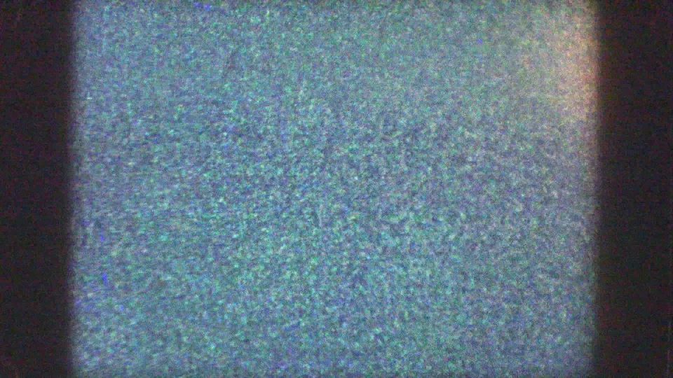 1957 Wisconsin 8mm frame with heavy gate obstruction, visible grain, bare trees, and a partial trailer-park exterior.