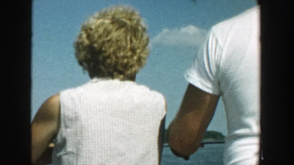 1957 Wisconsin 8mm frame showing a couple from behind on a boat, with the woman in a light top and open water ahead.
