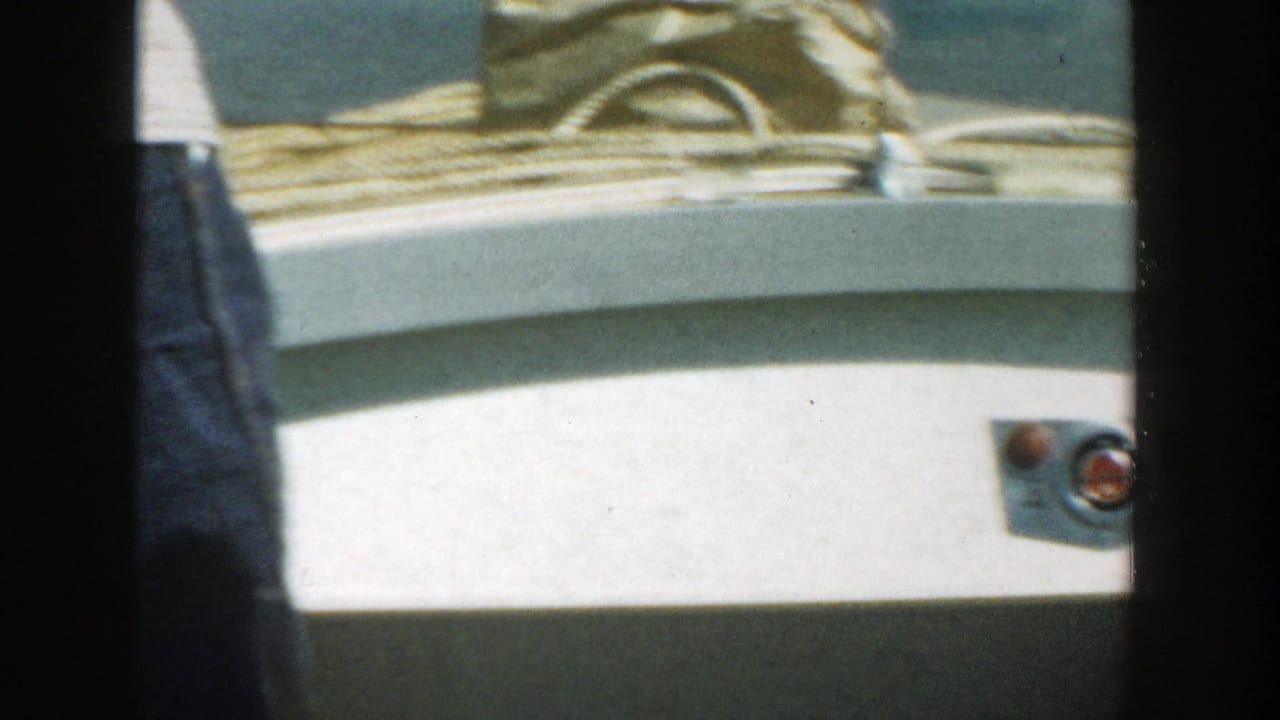 Denim-clad legs beside a white boat deck in bright sunlight.