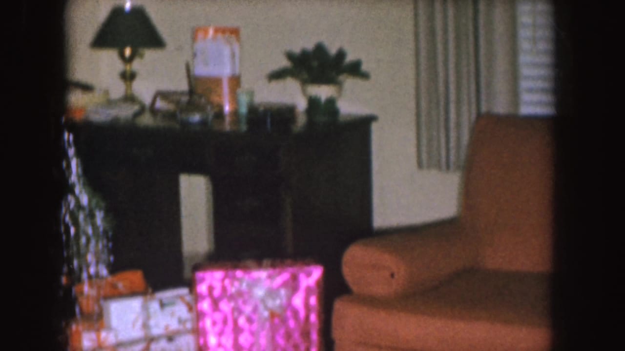 Christmas presents and a brown armchair near a decorated tree.