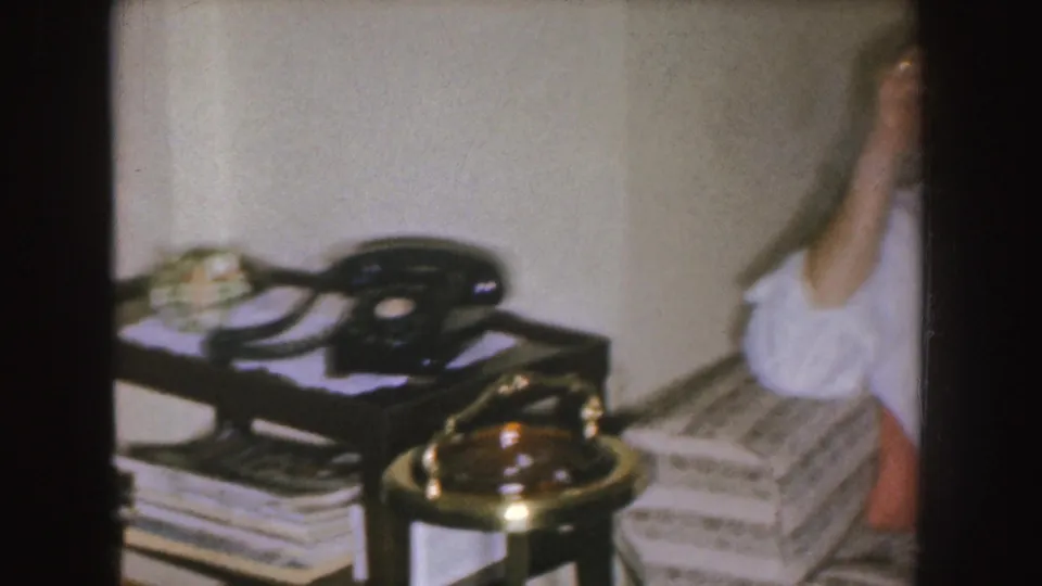 The final view centers on the telephone and lamp while the seated man is partly cropped at the edge of the frame.