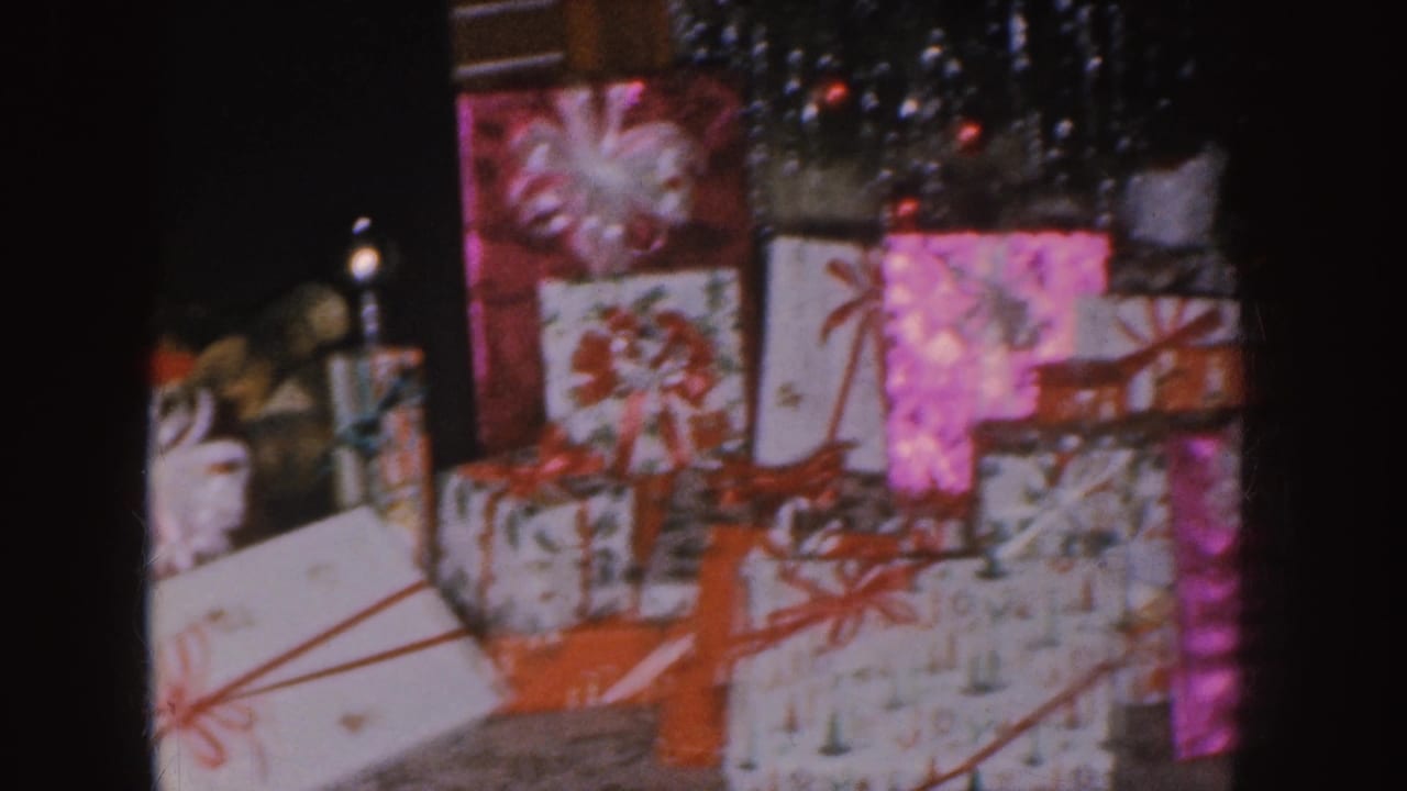 Stacked Christmas gifts with red bows and shiny decorations.