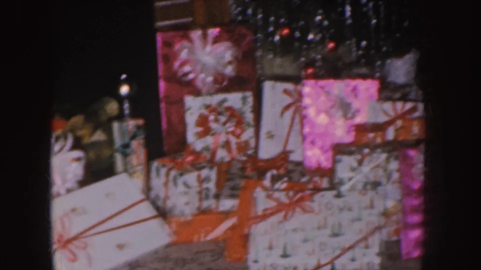 Nebraska 1955 frame of stacked wrapped presents beside tinsel and holiday lights.