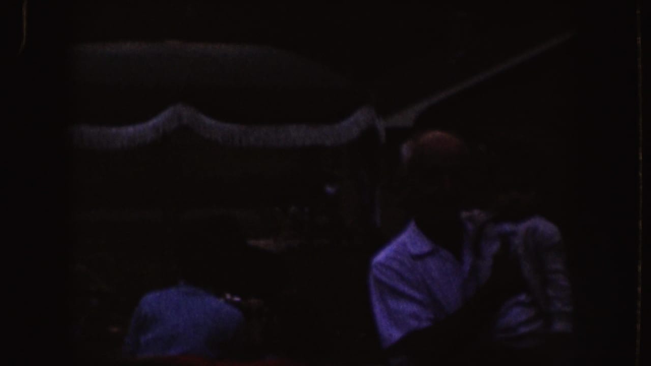 Dim room with seated adults facing an offscreen projected light.