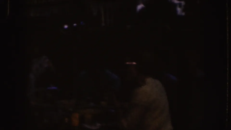Nebraska 1955 frame showing seated figures in a dim interior, with one viewer in a pale shirt visible near the front.