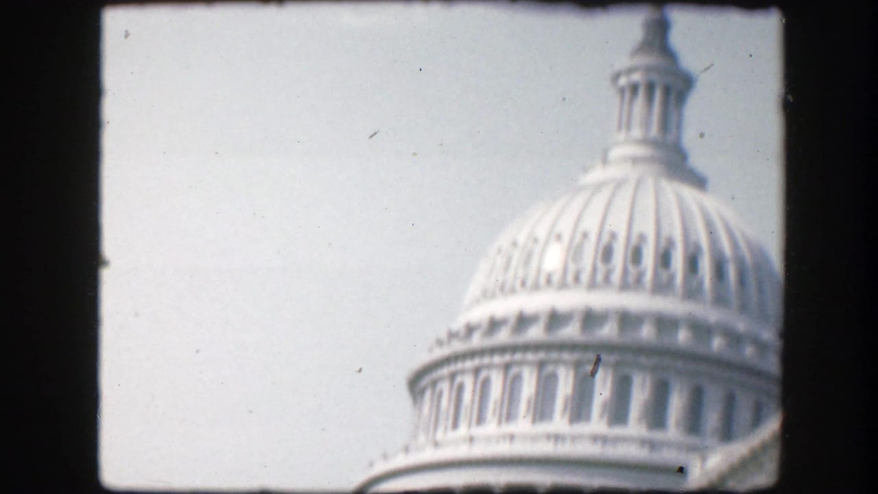 Close view of the U.S. Capitol dome against a pale sky.