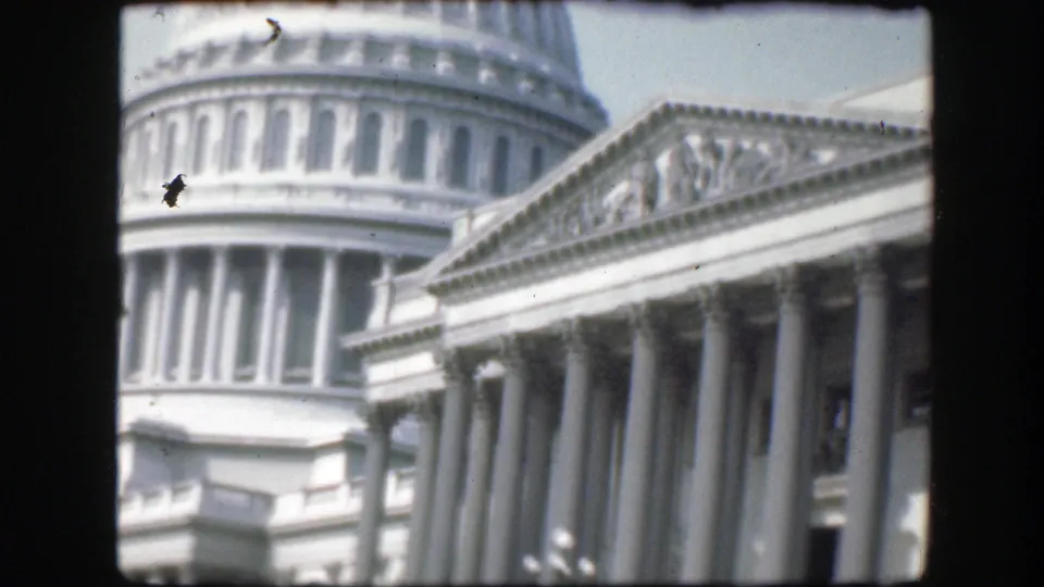 1945 Washington D.C. 8mm frame showing the Capitol dome, pediment, and classical columns from below.