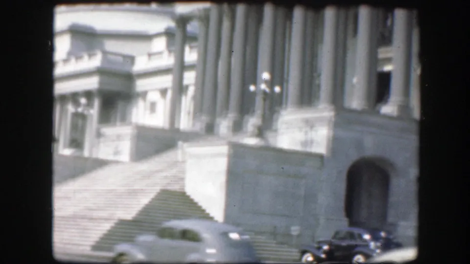 1945 Washington D.C. frame showing Capitol steps, columns, dome, and mid-century cars at street level.
