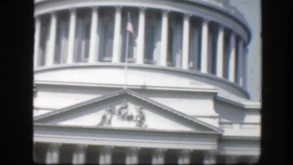 1945 Washington, D.C. 8mm frame showing the Capitol rotunda, flagpole, and neoclassical pediment beneath the dome.