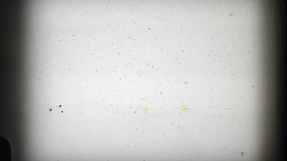 Overexposed 8mm frame from the 1961 Aspen travel clip, showing dark film borders and visible dust rather than a clear road view.