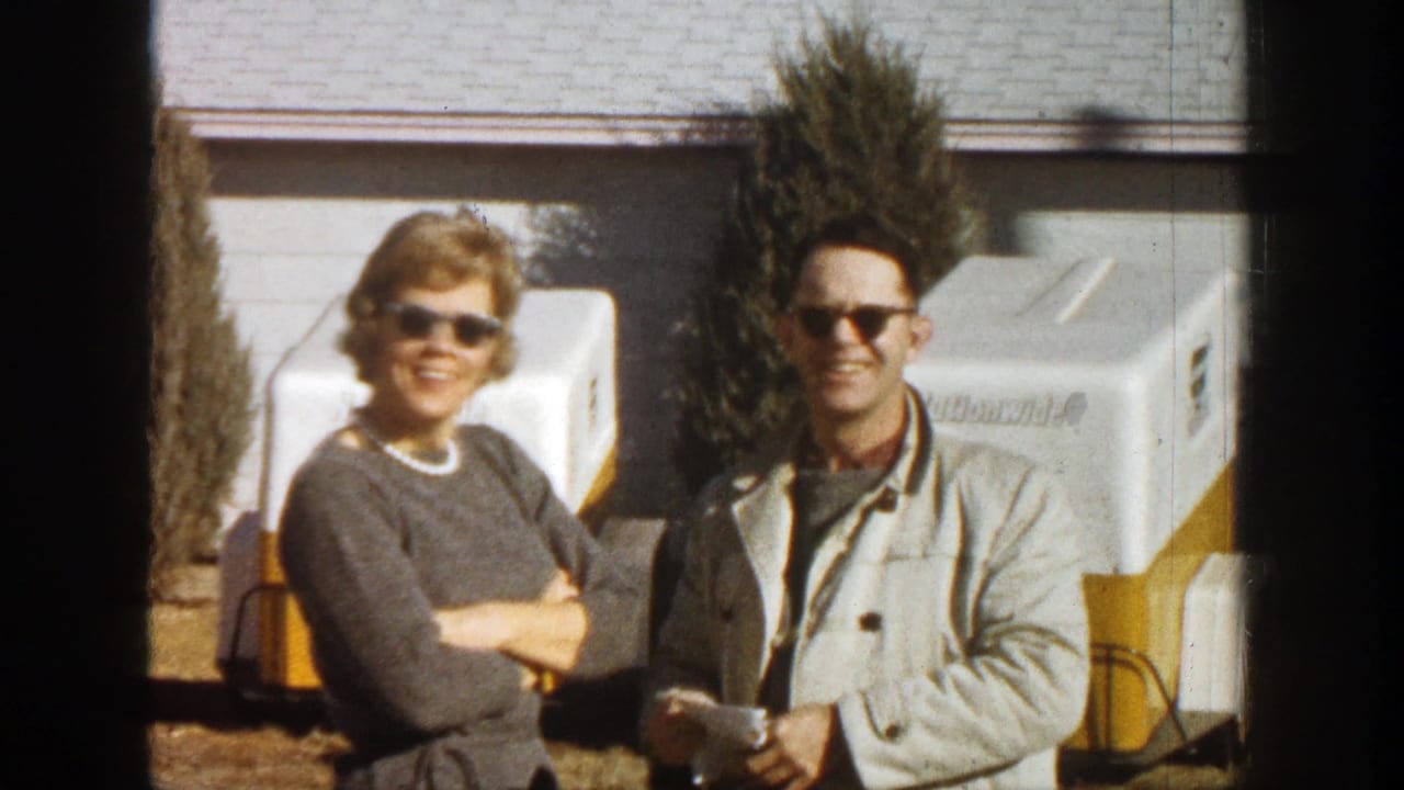 Smiling couple facing the camera beside portable coolers.