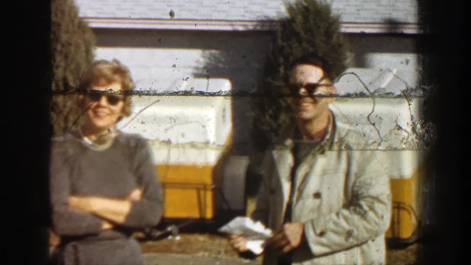 The couple remains posed near the coolers as visible scratches and wear cross the 8mm frame.