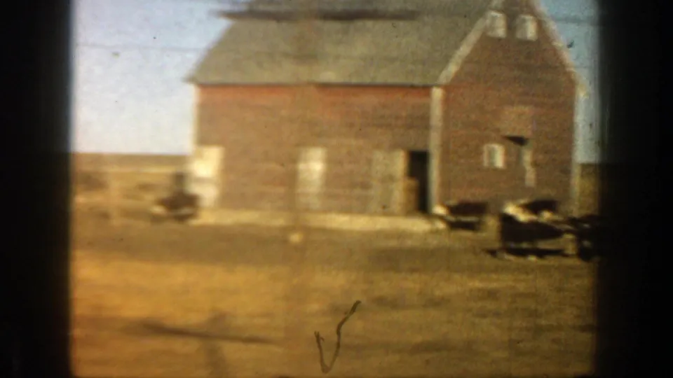 1961 Aspen, Colorado farm view showing a gambrel-roof wooden barn, dry pasture and cows along the right edge.