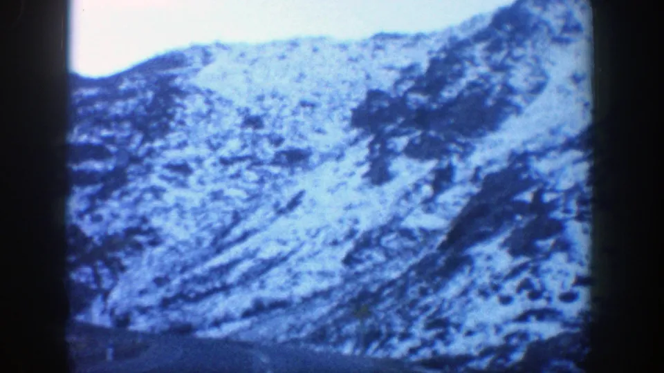 1961 Aspen 8mm frame showing a snow-covered mountain hillside viewed from a moving car.