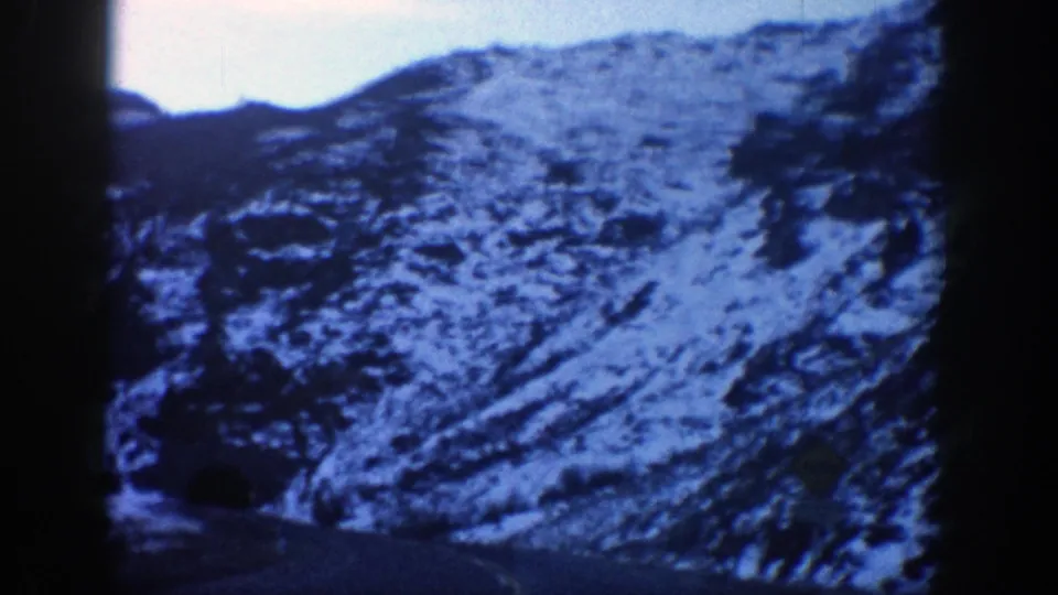 Aspen mountain slope fills the frame as the 1961 home movie continues from a moving vehicle.