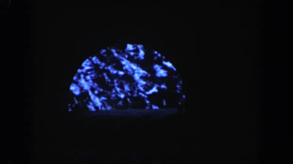 Inside or near the tunnel, the frame darkens around a small blue-tinted view of snowy mountain rock.
