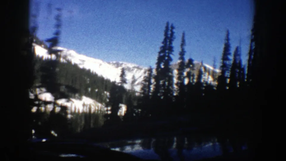 Aspen-area winter mountain landscape filmed from inside a moving vehicle on 8mm in 1961.