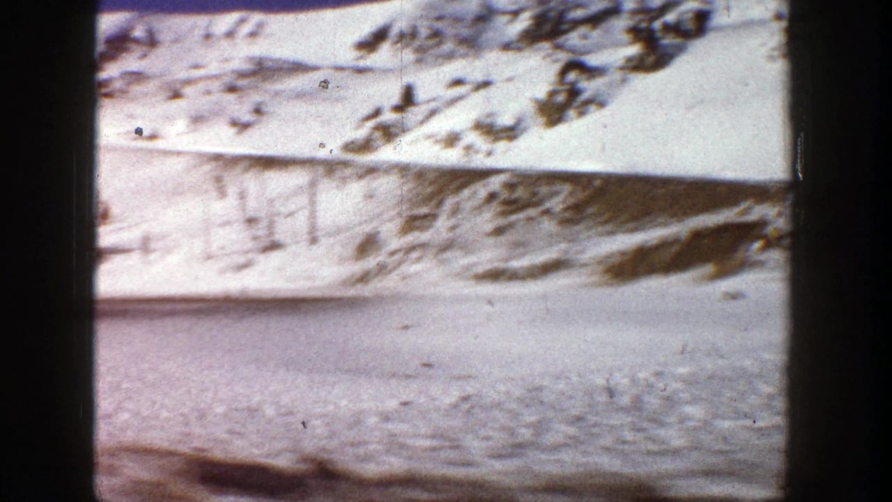 1961 Aspen, Colorado home-movie frame showing a snow-covered hillside and broad winter valley surface.