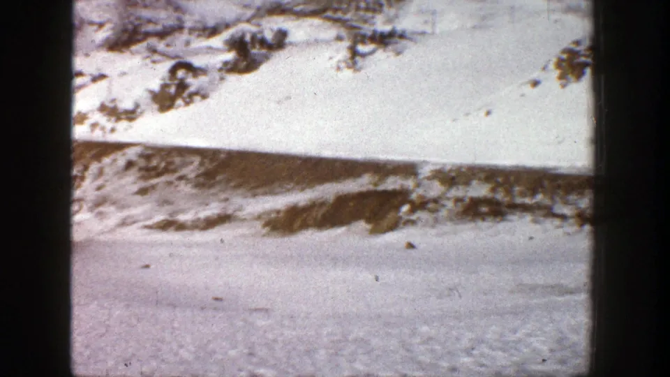1961 Aspen winter landscape with snow-dusted mountain terrain, exposed rocks, and scattered evergreens.