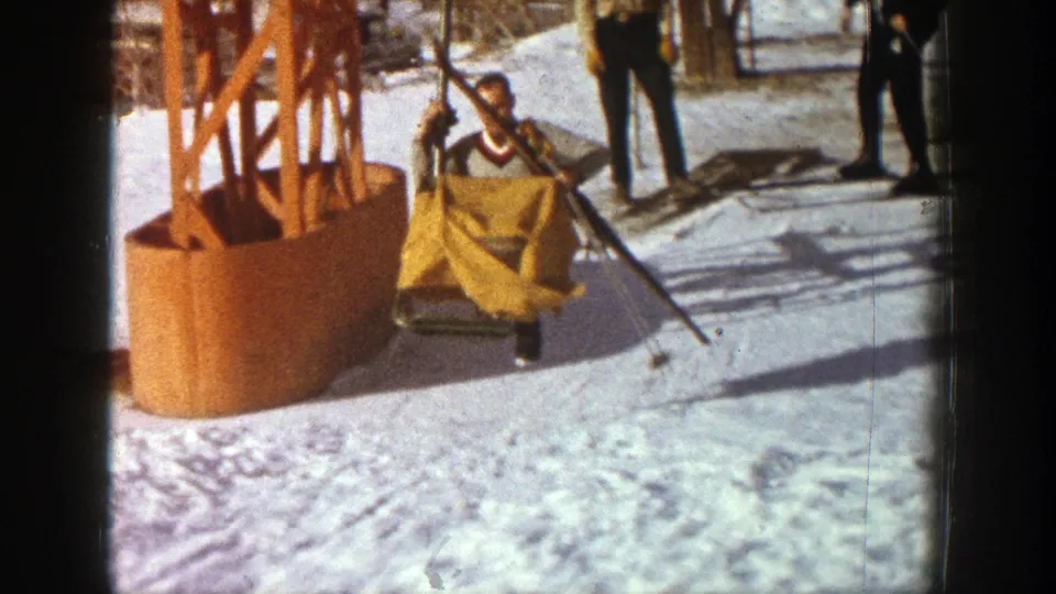 The Aspen ski-lift scene shows the yellow-covered chair beside the orange tower with people standing nearby on snow.