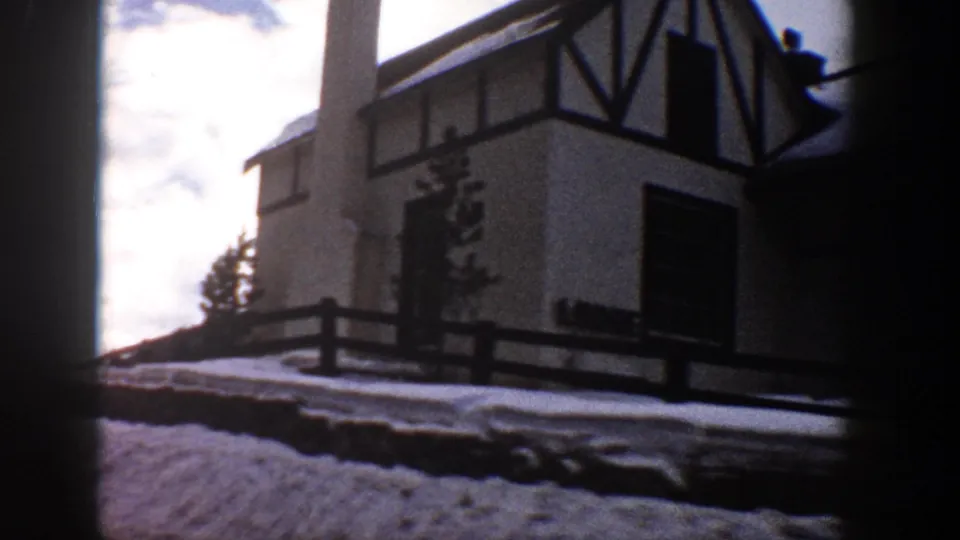 Aspen, Colorado lodge exterior in 1961, showing Tudor-style dark timber framing, snowbanks, and a fence.