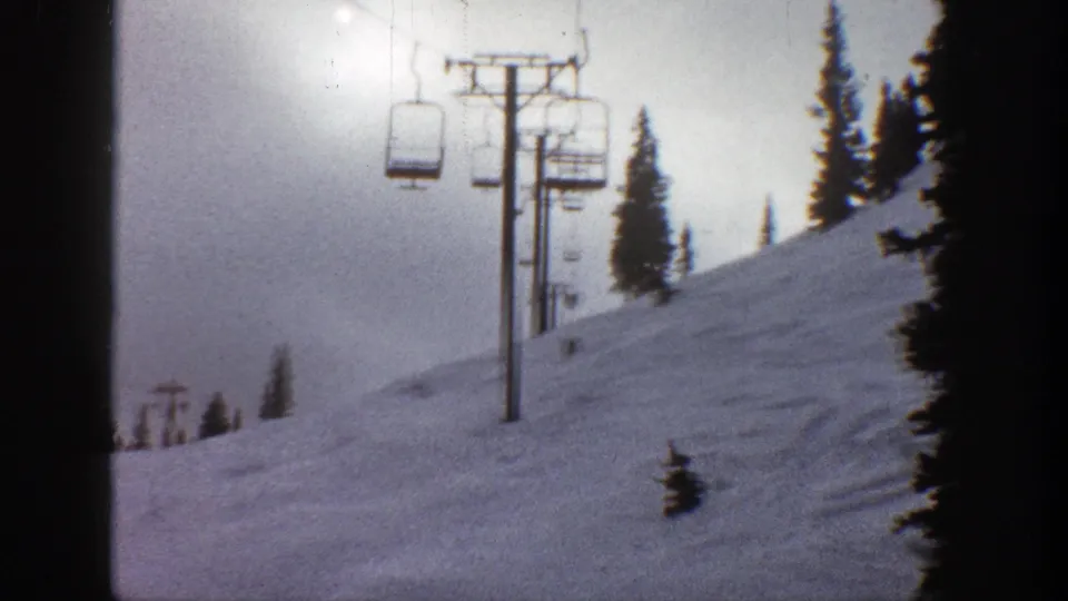 Static 1961 Aspen ski-area view with a chairlift tower, dark evergreens, and rolling snowfield.
