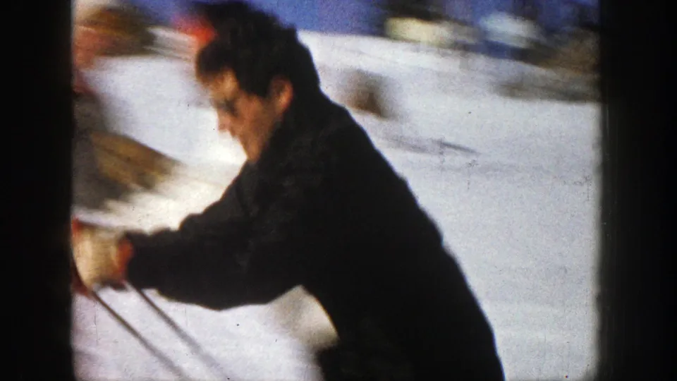 Motion blur shows the man skiing downhill across the snowy Aspen slope in the final moment of the short home-movie clip.