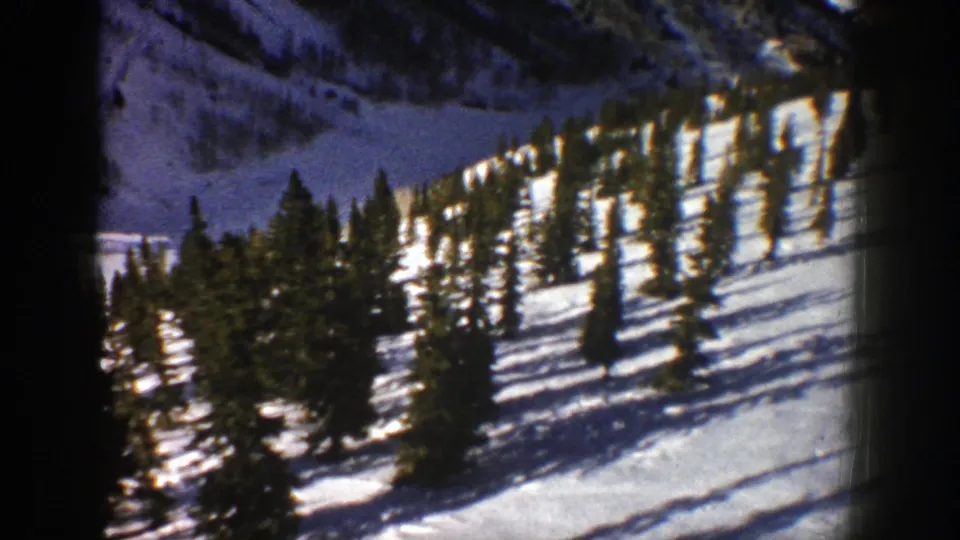 Aspen winter landscape frame from 1961 showing clustered evergreens on bright snow with dark 8mm frame edges.
