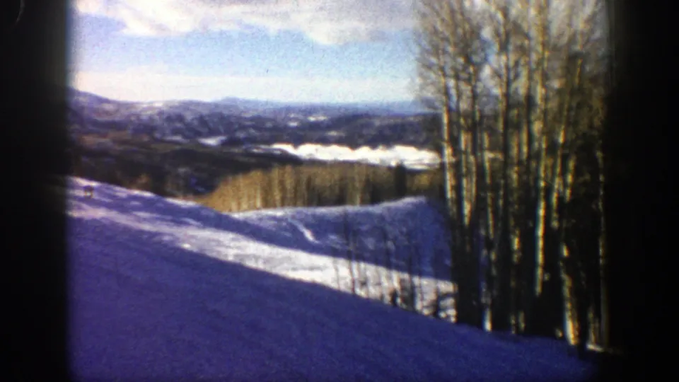 1961 Aspen, Colorado 8mm frame with snowfields, leafless aspen trunks, distant hills, and a bright winter sky.