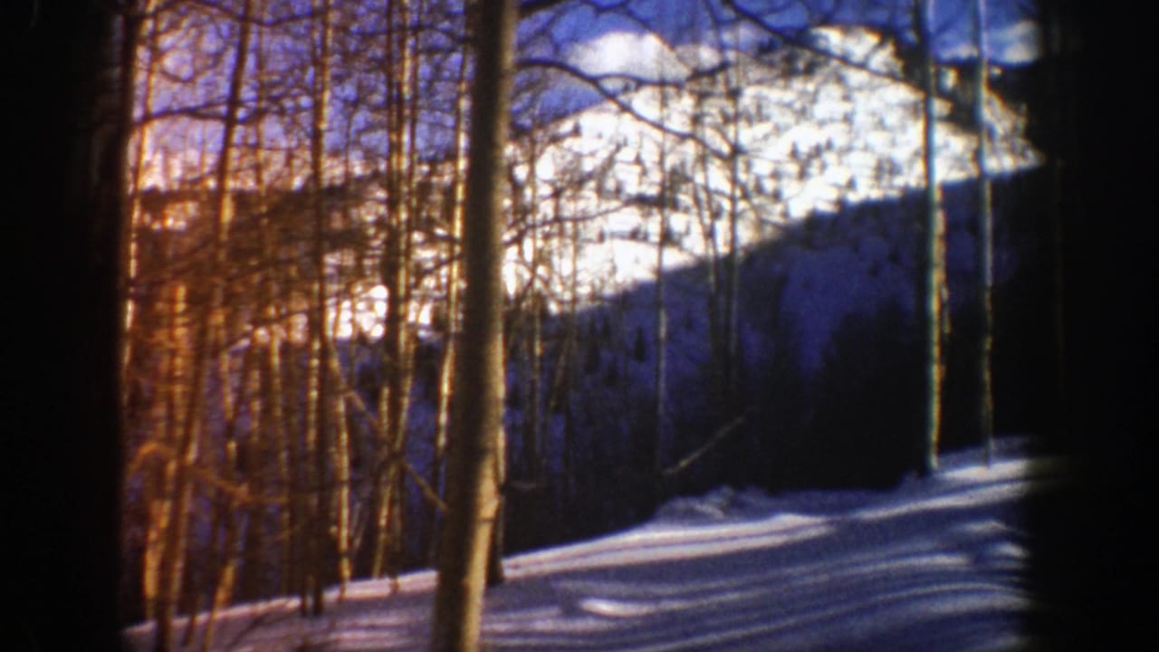 Aspen, Colorado winter landscape with bare trees, snowfields, and a distant ridge in 8mm color footage.