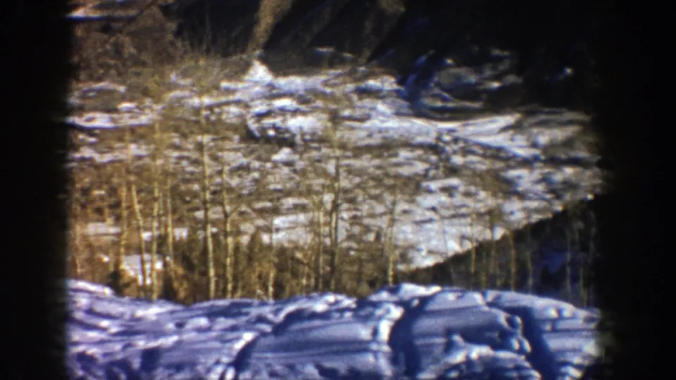 1961 Aspen, Colorado 8mm view of a snowy ski-area slope with bare aspen trunks and shadowed hillside.