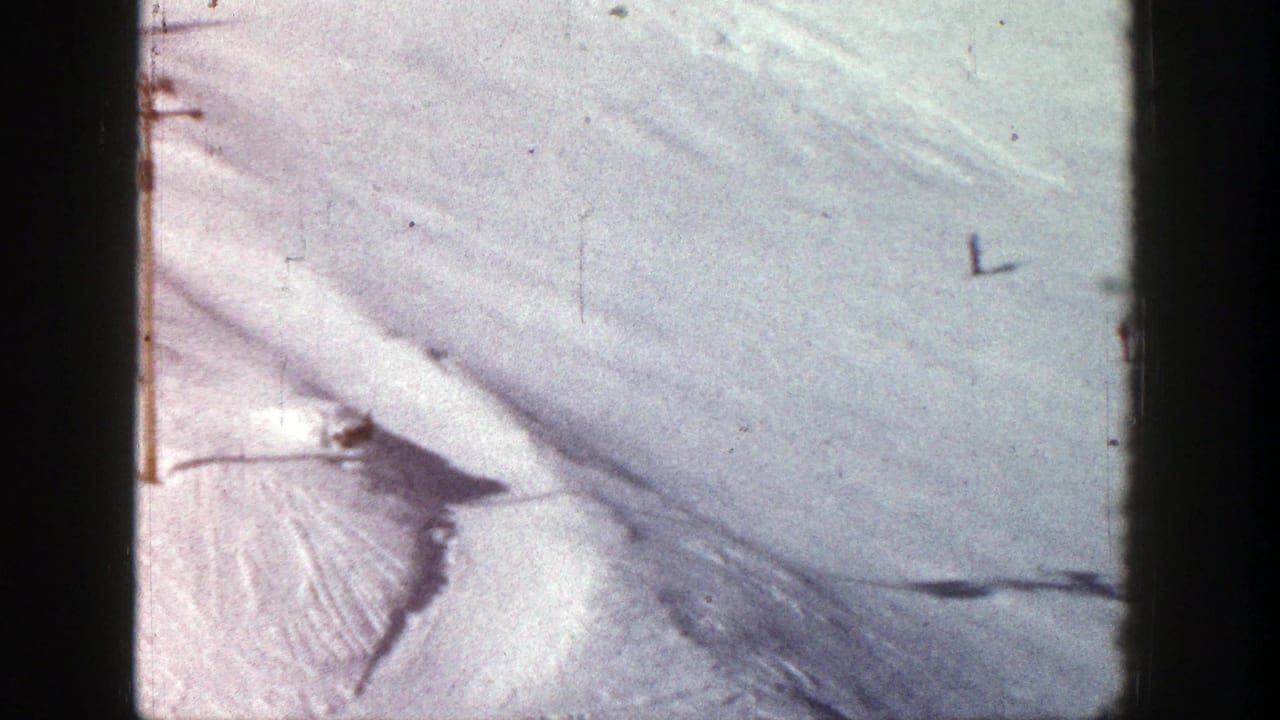 1961 Aspen home-movie frame showing distant skiers on a bright snow-covered slope from above.