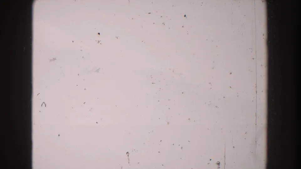 1960 Italy 8mm frame showing a pale blank field, heavy dark film divider, dust marks, and minor scratches.