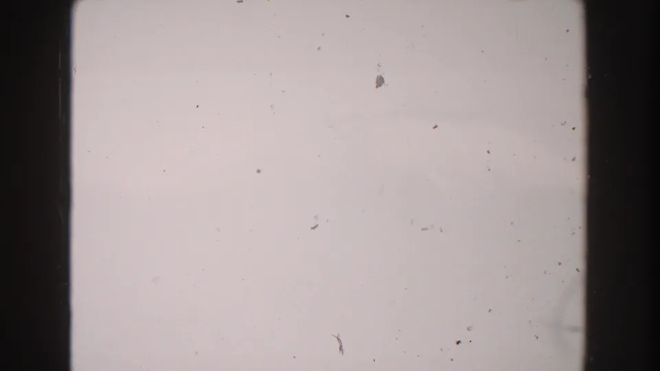 1960 Italy 8mm blank frame with pale exposure, dust, scratches, dark edge borders, and subtle film flicker texture.