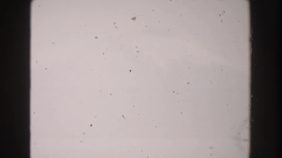 1960s Italy 8mm frame showing a light overexposed field with film dust, debris, and dark vertical edges.
