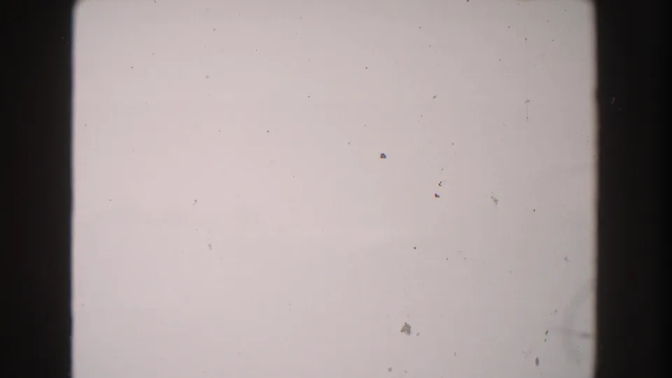 1960 Italy 8mm source frame showing a blank overexposed field with dark film borders, dust, and scratch marks.