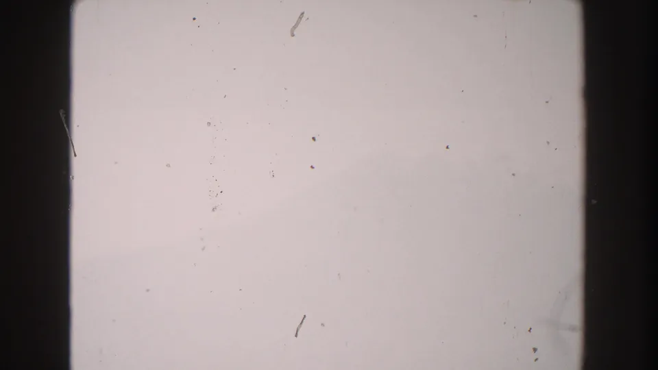 1960 Italy 8mm frame with a washed blank center, dark film edges, visible dust particles, and scratch marks.