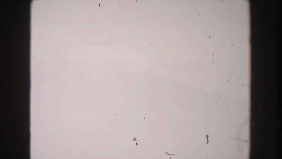 1960 Italy 8mm frame showing pale overexposed sky, dark film edges, and visible dust with no people or landmarks.