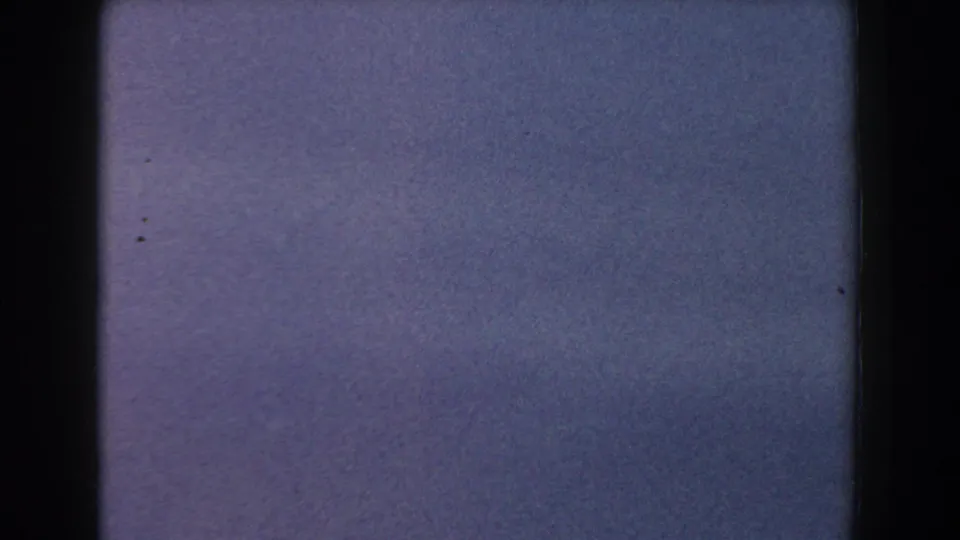 Soft 1960 Italy home-movie frame dominated by pale blue haze, grain, and minimal landscape detail.