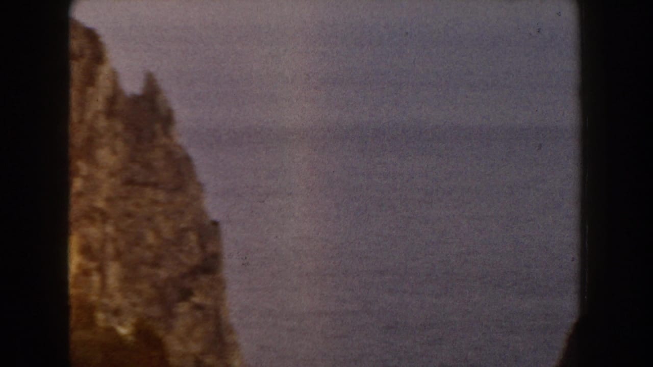 Soft 8mm view of an Italian rocky outcrop, partly obscured by the contact-sheet divider and framed against a hazy backdrop.