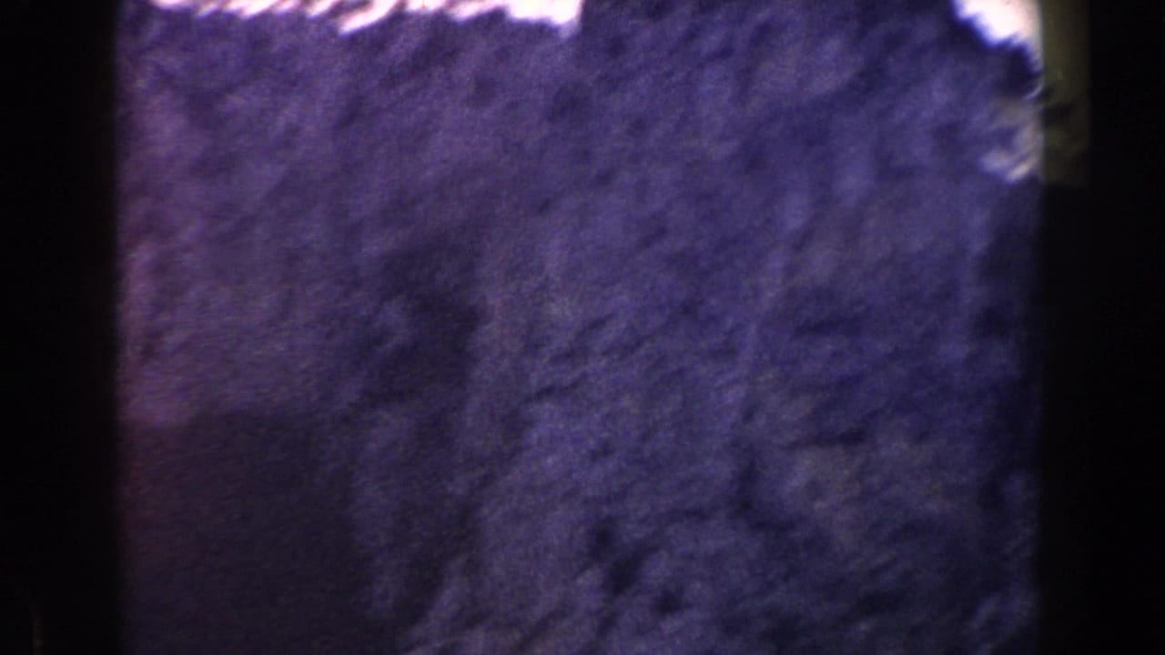 Close view of a dark rocky cliff face with film gate edges.
