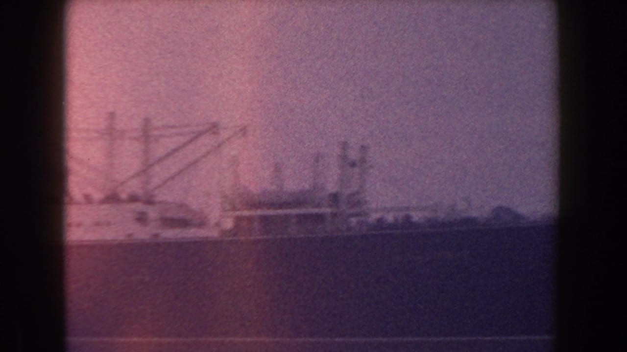 Large ship on water seen through a dark window frame.