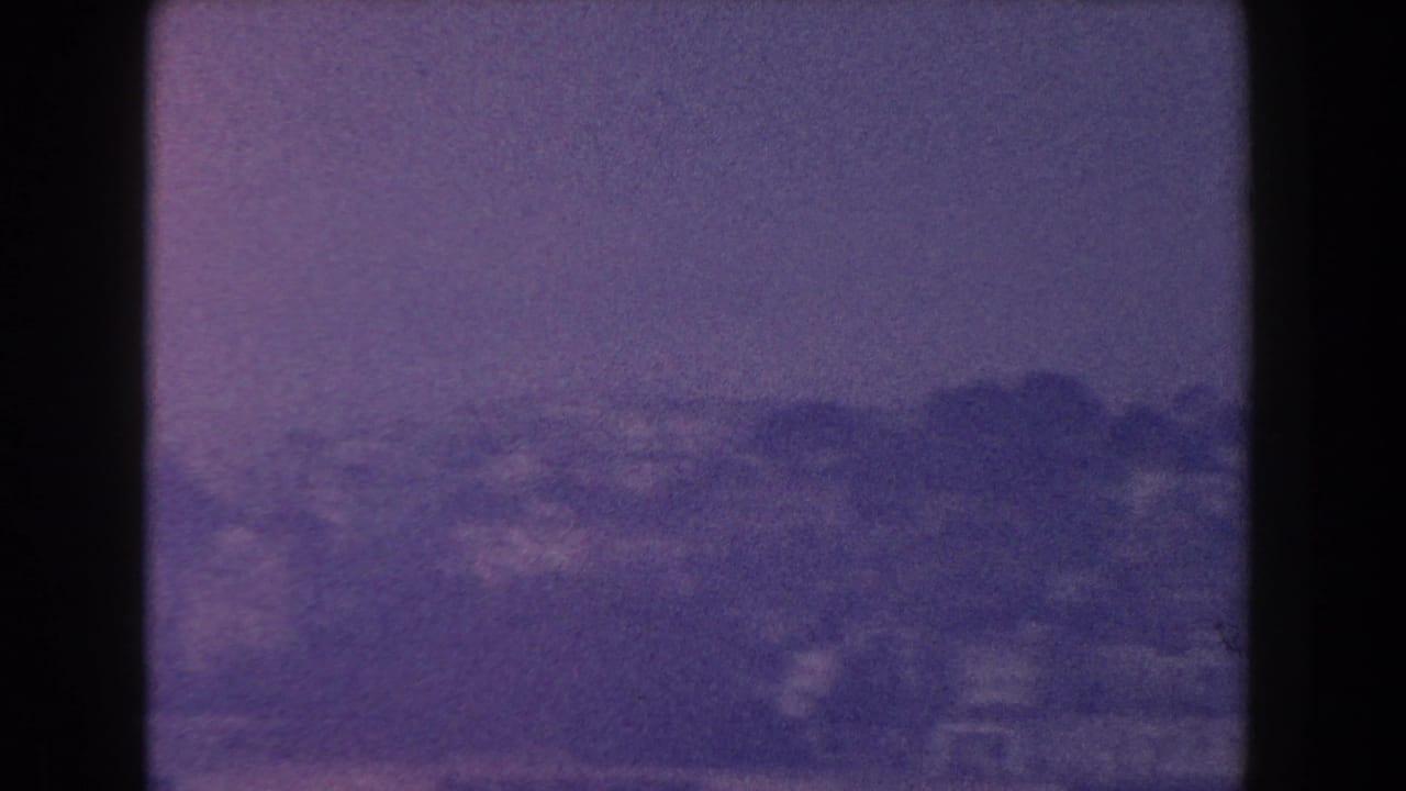 Distant coastline and buildings seen through a window.