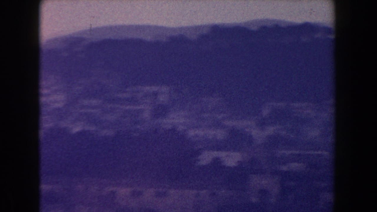 Distant town and mountain ridge with a small aircraft near the upper frame.