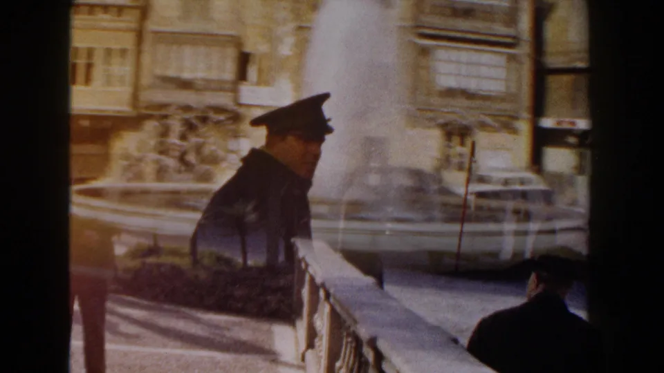 The horse-drawn buggy passes a stone fountain and parked cars in an urban Italian street scene.